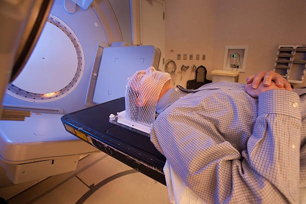 patient lying under a linear accelerator or linac for cancer radiation therapy